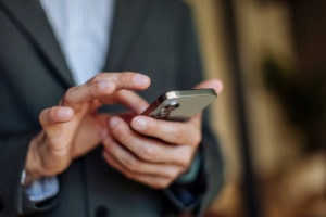 Homme en costume utilisant un smartphone